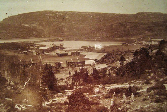 Bildet ovenfor er mulig fra 1897 og tatt fra sør side av Råk. Her er de to gårdene på Råk nærmest mot sør. Berge og Vorphaugen på henholdsvis vestre og østre side av Høvågen som var navnet på indre del av Vågen